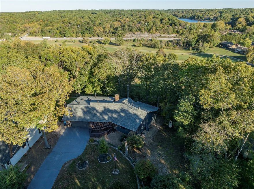 Welcome to this delightful ranch-style home, where stone accents & a pergola-covered entry create an inviting first impression as you arrive via the long private driveway. Inside, a stunning natural stone fireplace anchors the living space, complemented by rustic wood beams that add warmth & character thruout. Spacious kitchen - a chef’s dream, boasts a unique brick accent wall surrounding a 5-burner gas cooktop, with ample counter space & storage. Large windows bathe the home in natural light, enhancing the open, airy feel. Currently used as a third bedroom, the cozy den includes a built-in Murphy bed, a huge closet, & custom shelving—offering great flexibility for guests or home office use. Outside enjoy views of Kingswood golf course above the scenic "Danger Will Robinson" trail. In spring, the yard comes alive with mature trees, shrubs, & colorful perennials blooming in thoughtfully maintained flower beds.  Recent updates: Water Heater '24, HVAC '24, Roof '18.  On a 2-bedroom septic system.