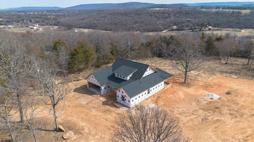 Picture this, a new construction home with a couple of acres, just out of the city life and it is conveniently located about ten minutes to Prairie Grove schools. Finishes include LVP flooring, quartz counters, and more. This exquisite home features quality finishes and attention to detail wrapped up in a well-designed split floor plan, bonus room for your office or homework space and a big covered porch to enjoy the views all while relishing the peace and quiet of your rural setting. The area surrounding the house is cleared and level, providing ample space for outdoor activities, gardening, or simply enjoying the fresh air. Meanwhile, the remaining wooded areas invite exploration and adventure, creating a delightful natural playground right in your backyard. Hurry by now while you can make this house truly your own with choices still available on paint, counters, floor colors and more. Taxes based on the vacant lot and will change. New parcel #tbd.