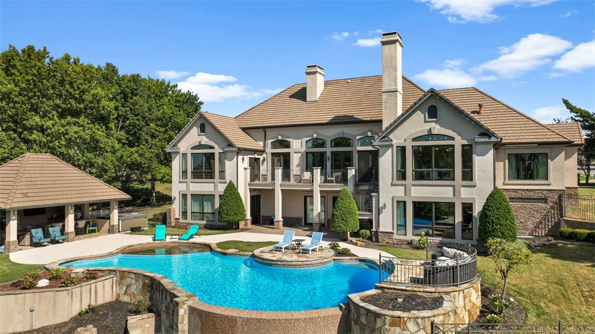 Welcome to 34 Pinnacle Drive. You will be amazed by the breathtaking panoramic golf course views overlooking the 7th & 8th holes on Pinnacle Golf Course. This luxury estate is perfect for entertaining. Step inside to architectural details, including a coffered ceiling, floor-to-ceiling windows, and stone fireplace. The gourmet kitchen has bar seating, new built-in refrigerator, new dishwasher, new countertops, painted cabinets, updated lighting, and a hearth room with fireplace. 3 of the 4 bedrooms are on the main level, including the primary suite with large closet, and luxurious ensuite bathroom. The 6-car garage has ample space to showcase your automotive collection. Downstairs includes a family room/theater with kitchenette, billiard room, bedroom, and the most incredible storage space (1,371 square footage not included in total square footage). The pool has been recently refinished, and the pool cabana has plenty of seating, including bar seating, to keep the chef entertained at the grill. This is a lifestyle