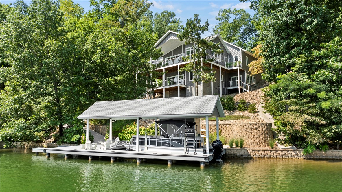 Dream lake house on Bella Vistaās Lake Loch Lomond with private two slip boat dock with boat lift. Built in 2020 by O.A.K. Homes on 1.02 acres, this two story luxury custom home features panoramic lake views from beautiful windows and wrap around covered decks. The top floor hosts an immaculate kitchen, living room with wood burning stove, screened-in porch, master bedroom/bathroom, half bath, and laundry. Downstairs you will find a second great room, two bedrooms, full bathroom and a bonus space that could be made into a bunk room or office. You will love the design choices and finishes that make this lake home move-in ready.
Right across the lake is Lake Point Marina & Restaurant, voted the best place to watch sunsets in Northwest Arkansas. Also nearby are Scotsdale Golf Course, Branchwood Recreation Center, miles of mountain bike trails, Bellas Table and the Bella Vista K9 Corral Dog Park.