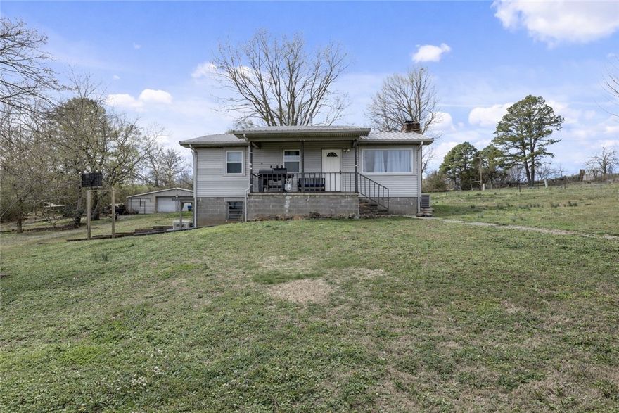 Enjoy a peaceful getaway on two acres with stunning Ozark hill views. This 2 bedroom home features a 416 sq ft bonus room under the house, offering great extra space for hobbies, storage, or a game room. Updates include new windows, flooring that was replace a few years ago, and a metal roof, with the HVAC and furnace replaced four years ago. The property also includes a detached metal shop, perfect for projects or additional storage.