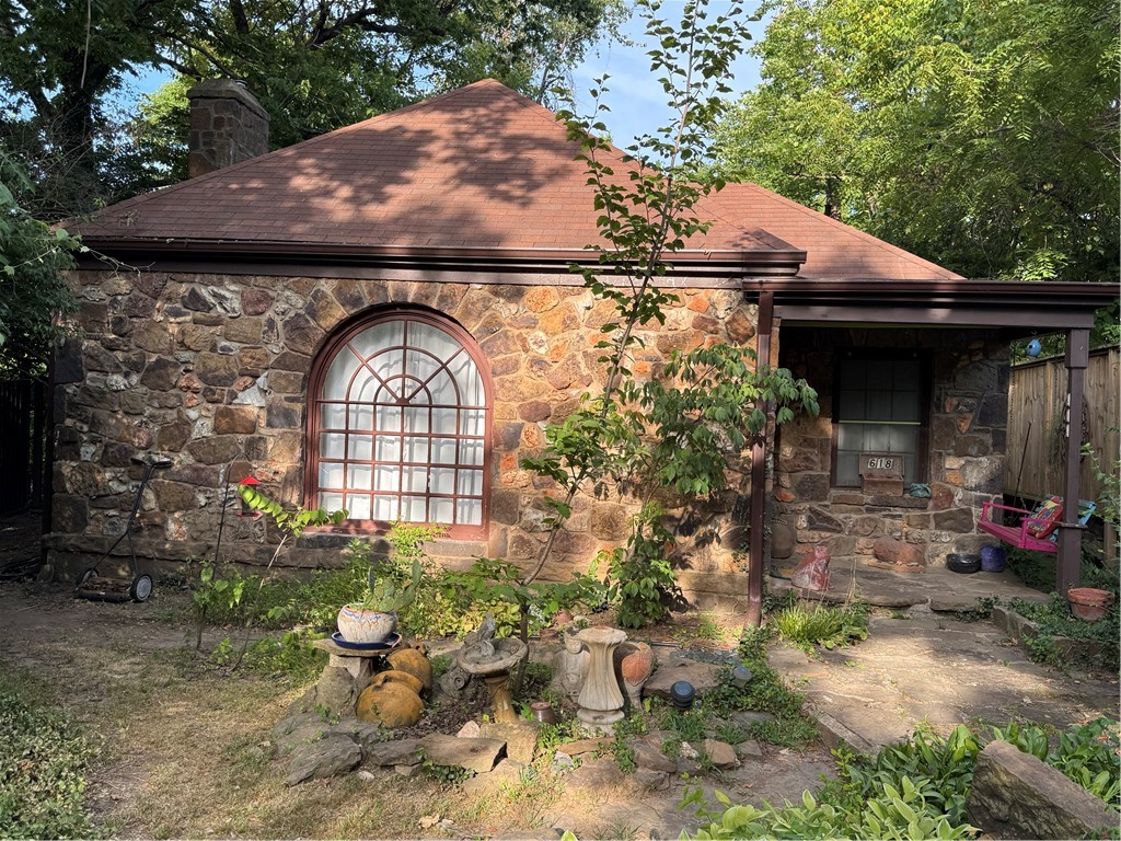 IF WALLS COULD TALK you could hear a lot from this 1936 stone cottage. Just steps from Wilson Park, U of A, with all the restaurants, shops and nightlife that Fayetteville has to offer. A Palladian window greets you and has had guests from U of A students of architecture to study the real thing. There are beautiful wood floors, some original tile, fireplace with built-in shelve surround. The dining space has access to one of two patios that are surrounded with greenery for privacy and bird sanctuary. A screened-in porch is the perfect place to enjoy coffee or favorite drink and enjoy those soothing bird sounds. The two bedrooms are equal distance from the hall bath. There is another full bath off the room behind kitchen being used as a den, along with a laundry room with access to the patio off dining. This house is in a very sought after location and would be great for walkability to the park swimming pool, sports courts and trails, university, and all other amenities in town. It will be sold As Is.