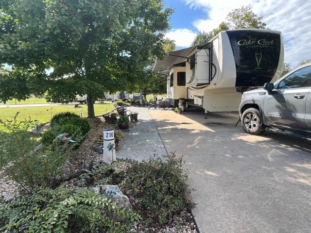 This is a lovely landscaped lot with an added 1000' sf +/- of patio space plus enough green space for the kids and grandkids to play in and a view straight to Table Rock Lake. Beautiful garden area with a unique water feature, driftwood, flowers and solar lighting along the white rail fence. Irrigation system for the green space and a separate one for the flowers. Coffee table, 2 chairs, bench and deck box stay. This lot is close to the bath house, pool and activities center building yet still in a quiet area. Don't miss this opportunity to own one of the bigger lots in the resort. Seller is negotiable.