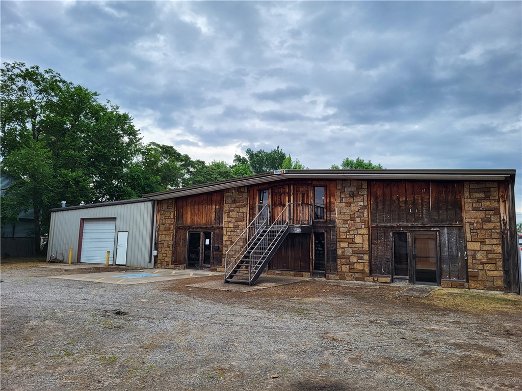 Large, open shop space available for the first time since 2017. The property was formerly used as an auto body repair facility, but now awaits your vision. This would be an ideal location to rehabilitate the structure as an auto repair, landscaping facility, tow yard, or construction company. There are 4 very tall roll-up doors for ease of access, ample office and customer lounge space, and even a small apartment on the upper floor for a caretaker or additional office space.