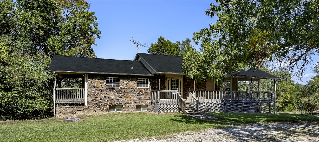 Open House, Nov. 17th 2:00-4:00. Nestled on 38 +/- acres that touches Beaver Lake, this property is a unique find for those looking to combine outdoor adventure with the comforts of home. Located just a short drive from Fayetteville or Springdale. The home features a wrap-around deck, ideal for enjoying the serene surroundings. Inside, the open-concept design provides a spacious feel, with the main bedroom and ensuite bathroom located upstairs. The upstairs living room features a fireplace insert, while downstairs offers two additional bedrooms, a full bathroom, and a large family room complete with a pellet stove for extra heat. Recent updates include a newer HVAC system, water heater, and roof. While the home needs a few cosmetic touch-ups, it's ready for you to make it your own. IMPORTANT- If the 2 parcels 001-13951-000 & 001-13952-000 are not bought together then owner will retain 5-7 acres less than 38.32.