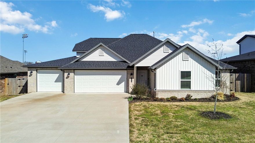 Immaculate 4-bedroom, 2-bath home with a 3-car garage, built in 2022, offering modern comfort and style in a prime location. This open-concept floor plan features a spacious living room, dining area, and a large kitchen island—perfect for entertaining. The kitchen is equipped with granite countertops, a gas range, stainless steel appliances and pantry. Enjoy high ceilings and a light, neutral interior palette throughout. The living room is anchored by a cozy gas log fireplace, creating a warm and inviting atmosphere. Durable luxury vinyl plank flooring runs through the main living areas, with tile in all wet areas and carpet in the bedrooms. Step outside to a screened-in covered porch—ideal for relaxing or grilling. The home offers just steps away access to nearby trails leading to Delford Rieff Park and the Prairie Grove Aquatic Center. Shops, dining, and entertainment are all within walking distance.  You can sit on your deck and watch the baseball game or fireworks on the 4th of July.  This is a great location!!