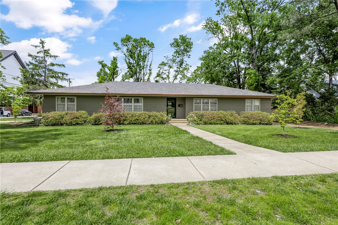 Welcome to 2,386 SF of timeless design & refined living in Downtown Rogers. This 3-bedroom, 2.5-bathroom home sits gracefully on a corner lot spanning nearly half an acre, offering a rare combination of privacy, style & walkability. Inside, real white oak flooring flows throughout the home, complementing warm wood paneling & classic mid-century details. The layout ft. formal dining room, formal sitting area & cozy den anchored by woodburning FP, perfect for reading nook or relaxed gatherings. Large windows fill the home with natural light, enhancing its warm, inviting atmosphere. Modern updates blend seamlessly w/original character, while thoughtful touches like copper gutters, & rain chains, add charm & functionality. The sunroom is a peaceful retreat, overlooking the beautifully landscaped backyard & inviting you to slow down & savor the view in every season. Whether you're hosting in the elegant dining space or enjoying a quiet moment by the fire, this home is full of soul & charm. A true gem in Downtown Rogers.