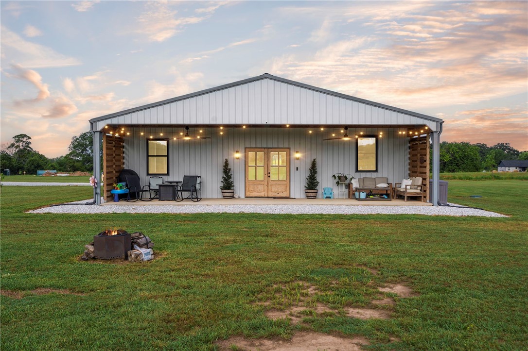 Welcome to your dream barndominium retreatābuilt in 2023 & set on 7+ acres with breathtaking views of Pea Ridge Military Park. Colorful sunsets & a sky full of stars greet you every night. Inside, this 3-bed/ 2-bath home blends modern comfort w/ country living. Soaring ceilings & large windows fill the home with light, highlighting the open-concept layout. The kitchen is made for gathering, with a massive butcher-block island that seats 8āperfect for entertaining. The living Rm features a sleek linear fireplace w/ built-ins, adding warmth & style. The primary suite offers an oversized walk-in shower, with a closet that connects to the laundry Rm for convenience. Step outside to a huge covered porch, ideal for barbecues, morning coffee, or simply soaking in the views. Built w/ fiberglass ceilings, foam board insulation/ 6ā rock wool walls, this home offers excellent efficiency- & A 4-car garage provides space for vehicles or hobbies. You won't want to miss this well-built home on land that offers peace & privacy