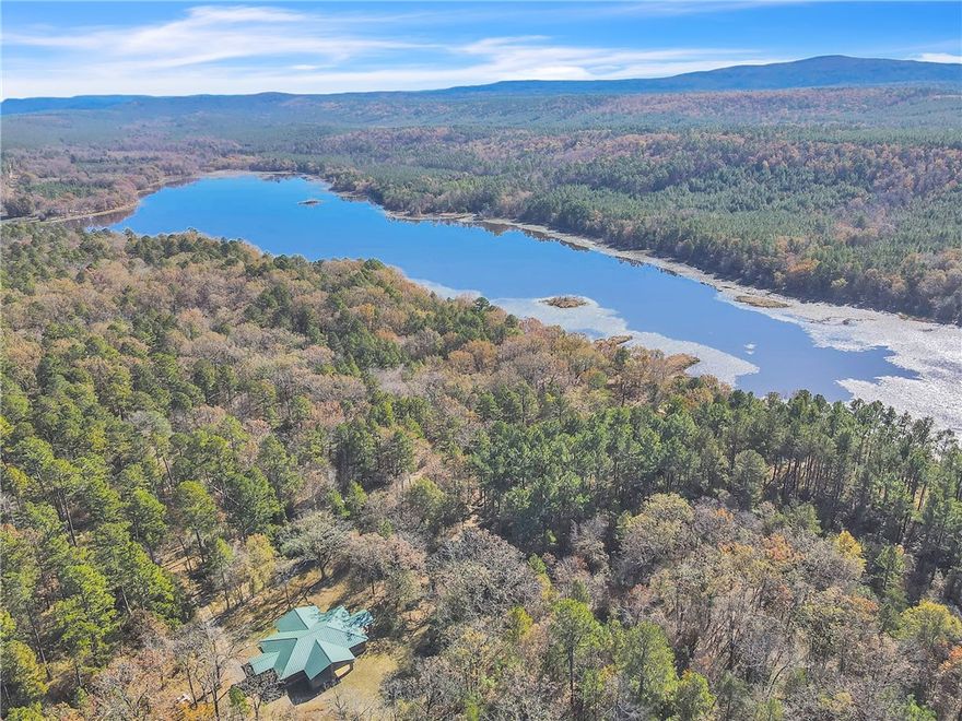 Set in the rolling foothills of the Ouachita Mountains, this 2,495± acre property offers the kind of scale, privacy, and natural beauty that rarely comes to market—anchored by a stunning 110-acre private lake that immediately sets it apart. It’s a place with a quiet sense of prestige, a rich history with the Boy Scouts of America, and a landscape built for recreation. This is a rare opportunity to acquire a mountain sanctuary worthy of generational ownership. The recreational value is outstanding. The property supports strong populations of whitetail deer, turkey, and black bear, and the layout naturally lends itself to growing and holding mature whitetails. The lake adds a rare dimension, having waterfowl potential, scenic fishing opportunities, and a setting that feels like a private mountain retreat.  an array of functional improvements that elevate the property: multiple cabins, pavilions, a dining hall, rifle and skeet ranges, a shower house, canoe shed, and much more.