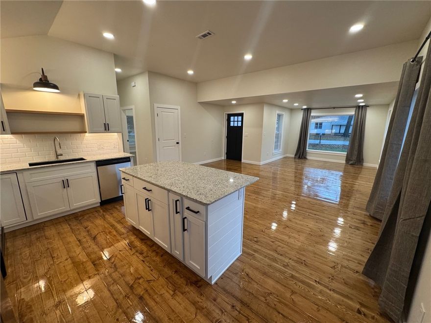 Beautifully renovated 2-bed, 2-bath home within walking distance to historic Downtown Siloam Springs! Step inside to an inviting open layout featuring gleaming refinished hardwood floors, fresh interior paint, and vaulted ceilings that bring in incredible natural light. The stunning kitchen offers granite countertops, new cabinetry, subway tile backsplash, open shelving, and stainless-steel appliances. Both bedrooms are generously sized with vaulted ceilings and recessed lighting, while the bathrooms feel straight out of a designer magazine—complete with custom tile work, modern vanities, upgraded fixtures, and a spacious shower/tub combo. The mudroom features charming star-pattern tile, built-in storage, and a bench with hooks for easy everyday organization. Save money on utility bills- this home is energy efficient, with new spray foam insulation throughout. Enjoy the convenience of being just a short walk from parks, coffee shops, restaurants, Siloam Springs schools, and all the charm of downtown.