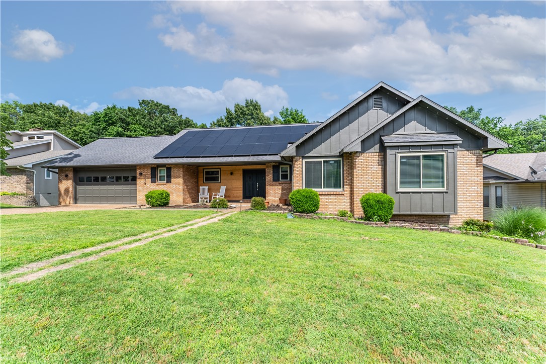 Has your utility bill ever averaged $14 per month? Now is your chance! Check out this stunning San Jose Estates home, perfectly located between Springdale and Fayetteville. Walking distance to Lake Fayetteville Park and restaurants. The double-sided fireplace also serves the eat-in dining area with tons of natural light. It's next to the large kitchen with distressed white cabinetry, granite countertops, tiled backsplash and double oven- also a pantry & island with electric range & seating space. The primary suite is on the main floor and offers private deck access with an ensuite featuring double vanity, tub, & shower. There are 2 more bedrooms on the main floor &l full bath. Downstairs, the fully finished basement is perfect for entertaining with a wet bar & bonus room that has a wall full of windows and a stone fireplace. Lower floor also has laundry, two bedrooms, & theater room. Covered patio has outdoor access to upper deck, too, overlooking the large yard. Solar panels are paid off and convey to buyer.
