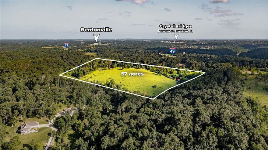 Opportunity awaits just beyond the Bentonville city limits! These 57 wooded acres offer a rare blend of privacy, proximity, & potential—perfect for those with big ideas & bold visions. With no city zoning restrictions, you have the freedom to create without limitations. Surrounded by residential and recreationally zoned land, this property sits less than 4 bikeable miles from Crystal Bridges Museum, the AWSOM campus, & the iconic OZ Castle & Slaughter Pen MTB trails. The area is buzzing with development, making this a strategic investment in Bentonville’s rapidly growing town. Imagine a luxury estate community nestled among the trees while remaining connected to the heart of Bentonville. Utilities: Electricity available at the street, propane for gas, suitable for standard septic systems, & well water needed. Located in the highly sought-after Bentonville School District. East Bentonville is ready for its next luxury community—could this be the future site of your legacy project? Come experience it for yourself.