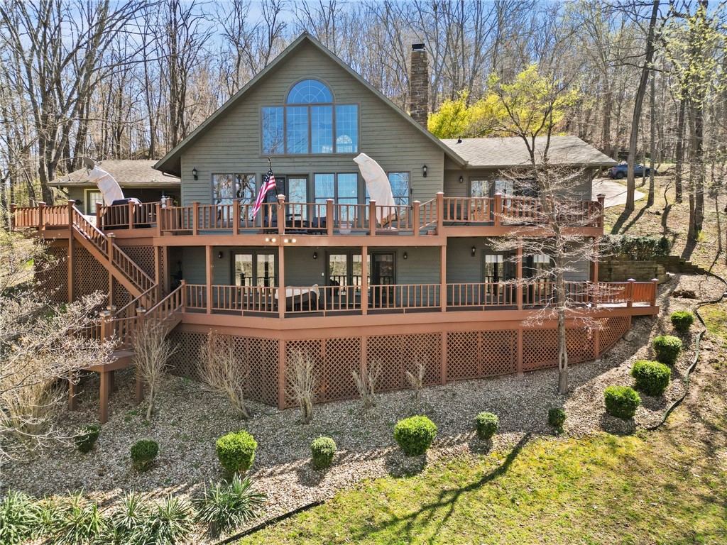 Welcome to this spacious lake front home on Beaver Lake in the picturesque Hoot Owl Hollow just off of Indian Creek in Garfield, AR. The main level features walls of windows, soaring ceilings, beautiful wood burning fireplace, and wonderful craftsman style details. The open concept floor plan leads to a kitchen with granite countertops, professional appliances and dining area. The main level primary bedroom offers lake views and en-suite bath. The loft area is currently being utilized as an office, but has so many possibilities. Downstairs the walkout basement level features a second living area, native stone wood burning fireplace, 3 bedrooms and 2 full baths, and a wet bar.
Outside enjoy beautiful landscape, upper and lower decks, and a flagstone pathway to the 2 slip private dock, ready for you to enjoy this summer out on the lake. Don't miss out on this rare opportunity to own a Lake Front home and private dock! Schedule a showing today!!