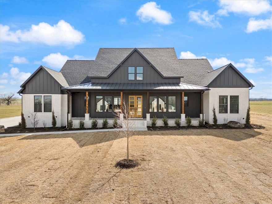 Enjoy elegant living in this spacious 4BR, 3.5BA home on 1 acre near Beaver Lake, east of Fayetteville with easy access to Springdale. Designed with custom luxury finishes, the chef’s kitchen features a 9x6 island with abundant storage, Café appliances with Bluetooth, 6-burner gas cooktop, pot filler, quartz countertops, under-cabinet lighting, and soft-close custom cabinetry. A massive pantry offers shelving, outlets, space for a second fridge, and butcher block counters. Large windows fill the home with natural light, highlighting the warm 9” LVP flooring. The vaulted living room showcases a wood beam accent, built-ins, and a gas log fireplace. Tile surrounds all showers. The covered back patio includes a wood plank ceiling, gas fireplace, and outdoor kitchen with grill, sink, quartz counters, and fridge—plus half bath access, ideal for a future pool. 8’ drop zone with storage and 34x25 3-car garage with 220.This elegant retreat offering luxury, comfort, and thoughtful design is an exceptional place to call home!