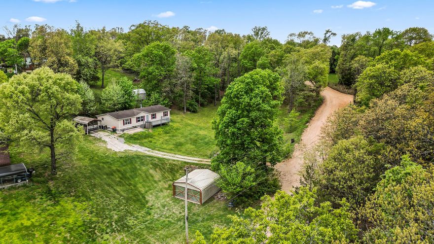 Situated on a permanent foundation, this home is eligible for FHA financing, making it an excellent option for a wide range of buyers. This 4-bedroom, 2-bath home sits on 1.73 acres.  Inside, you’ll find durable wood laminate flooring throughout, creating a clean look that’s easy to maintain. The spacious living area features a cozy wood-burning fireplace. The home has seen important updates, including a new HVAC system installed in 2020 and a brand-new water heater in 2026. The functional layout offers a spit floor plan of 4 comfortable bedrooms and 2 full bathrooms. Whether you’re looking to garden, entertain, or simply enjoy the outdoors, there’s plenty of space to make it your own. also included is a large 20x18 storage/shop building—ideal for lake toys or additional storage. Location is a standout feature, with the home just 1 mile from Hickory Creek Marina and only 1/2 a mile from a public boat ramp. If you enjoy boating, fishing, or lake days, you’ll love how convenient this property is to the water.