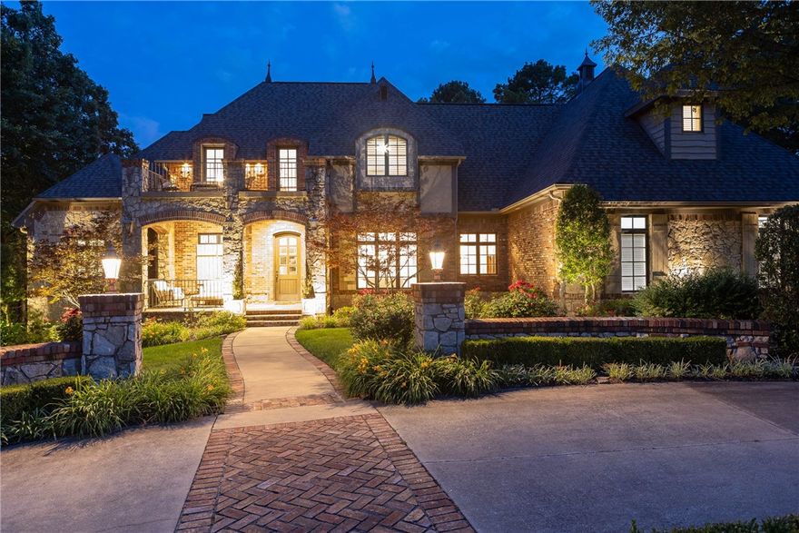 Timeless elegance meets elevated living in this European-inspired Parade Home, set on a professionally landscaped lot overlooking the 11th & 12th holes at Blessings Golf Course. Gourmet kitchen stuns with JennAir appliances, granite counters, travertine floors, & a grand island. The Living room features soaring ceilings, custom mantle, & a striking two-story fireplace. Offering a peaceful retreat, the primary suite includes deck access, dual vanities, jetted tub, custom walk-in closet & two private water closets. Upstairs includes two ensuite bedrooms & a suite with kitchenette—perfect for guests or mother-in-law space—while the lower level adds a second kitchen & living area, theater room, gym, sauna & guest suite. Designed for unforgettable entertaining, the outdoor space features a tiled covered deck with gas fireplace, heated gunite pool with hot tub, outdoor kitchen & multiple patios. Every inch of this 7,000+ SF home is curated for comfort, beauty, & seamless entertaining—where luxury meets everyday living.