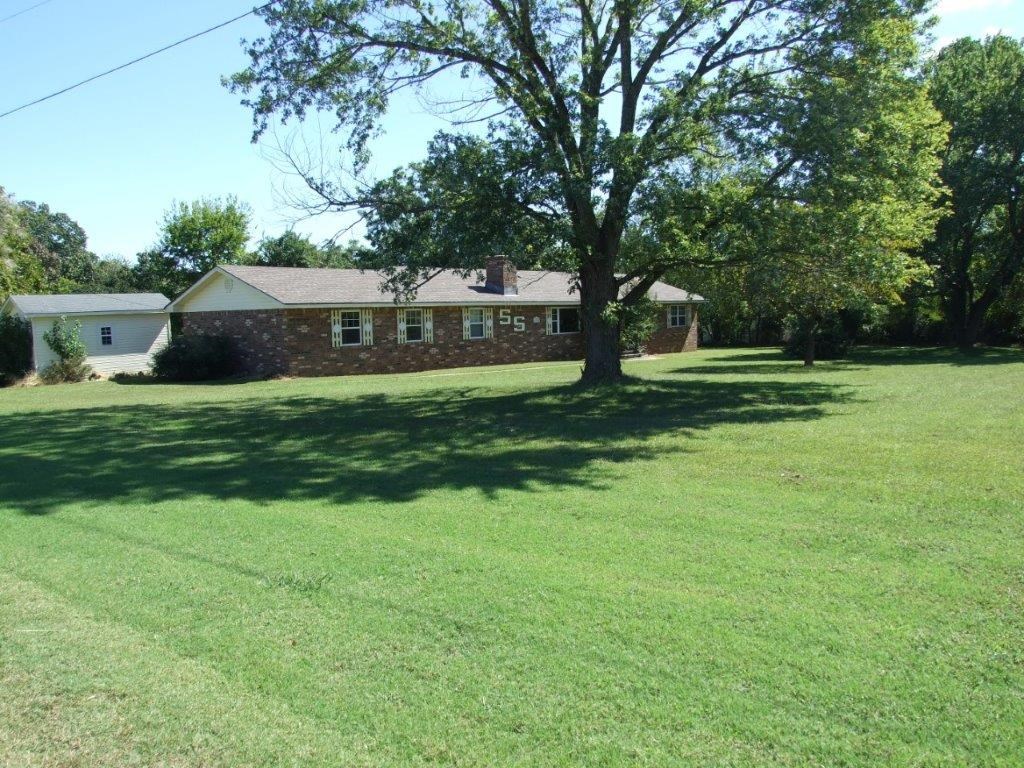 Peaceful rural setting with large trees, small fenced area with open back & side yard for kids to run and play, covered patio with privacy fence. Three detached storage buildings, above ground concrete storm shelter, three bedrooms and two baths, living room, den, and dining room.