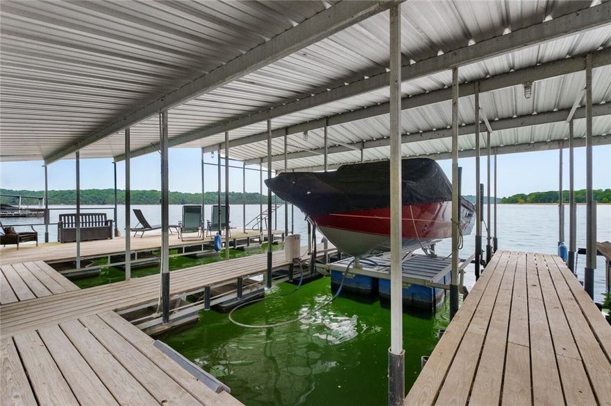 Youāll love this lakefront showstopper featuring soaring glass panels that bring the outdoors in. A rare find, this property is just steps away from the co-owned 4-slip boat dock w/swim deck. Two 10' x 26' slips & lifts convey.  This 4,374 SF retreat balances luxury with comfort, offering multiple entertainment areas that flow seamlessly from indoors to outdoors. The main-level primary suite is a sanctuary including a sitting area, spa-inspired en suite bath and separate laundry room. A second Primary, Family Room, and Laundry Room are located on the lower level, along with an office and fitness room. Significant updates include a remodel of all five bathrooms, installing hardwood floors, new roof, 3 HVAC units, whole-house generator, new septic system, and fresh interior/exterior paint. This is a rare opportunity to claim the lakefront retreat you've long desired.