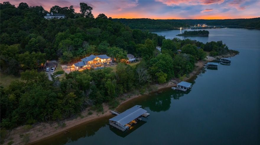 You’ll love this lakefront showstopper featuring soaring glass panels that bring the outdoors in. A rare find, this property is just steps away from the co-owned 4-slip boat dock w/swim deck. Two 10' x 26' slips & lifts convey.  This 4,374 SF retreat balances luxury with comfort, offering multiple entertainment areas that flow seamlessly from indoors to outdoors. The main-level primary suite is a sanctuary including a sitting area, spa-inspired en suite bath and separate laundry room. A second Primary, Family Room, and Laundry Room are located on the lower level, along with an office and fitness room. Significant updates include a remodel of all five bathrooms, installing hardwood floors, new roof, 3 HVAC units, whole-house generator, new septic system, and fresh interior/exterior paint. This is a rare opportunity to claim the lakefront retreat you've long desired.
