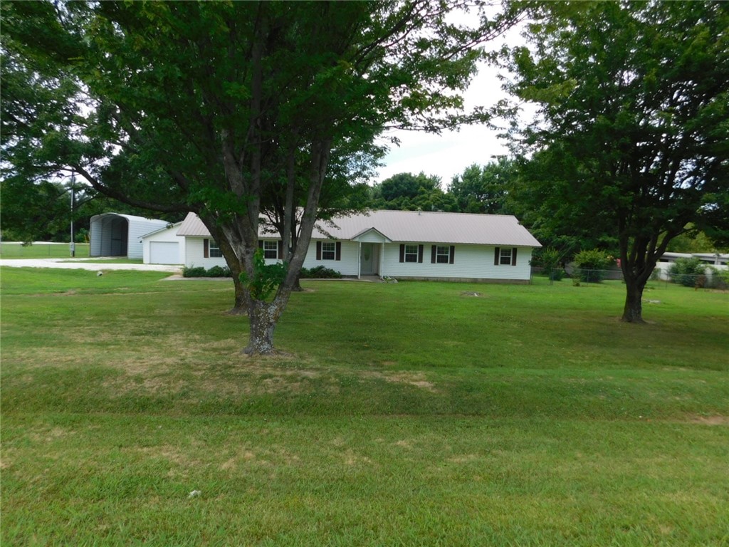 What a fantastic deal - this property can be residential or commercial!!!! Check it out - It has a huge 1.69 acre parcel, fully fenced, with a house in great condition, metal roof, a 24x24 shop with a garage door, and it is RIGHT ON HWY 62! The home is 2 bedroom, 2 bath, 2 car garage, with an 11x15 family room that could easily serve as a third bedroom. Large living room, large utility, 22x22 garage, glass front storm door, carpet and ceramic tile floors, blinds, and lots more! You gotta see this to appreciate it!