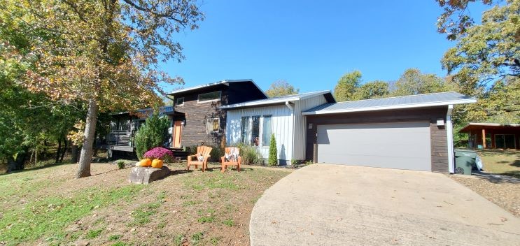 New Price! Custom contemporary home with gorgeous views from the front deck. Abundant white oak hardwood floors; Kitchen, living and dining are totally open in this 5 bedrooms, 3.5 bath home. Kitchen boasts quartz counter tops, beech wood cabinets, stainless appliances, gas range, tons of counter space, pantry, and huge breakfast bar. Two car garage and extra parking for the boat, trailer, or RV. Master suite is on the main level, A couple of steps up takes you to 3 bedrooms & full bath. Just downstairs enjoy a private suite bedroom with bath & extra storage or office!