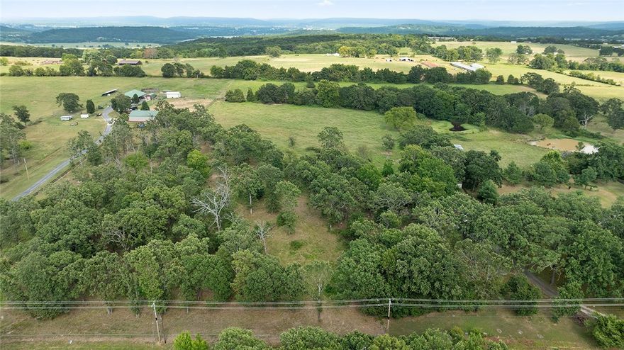 Hardwoods, paved road, and room to build—this 3.41-acre tract on Wedington Blacktop checks all the boxes.  With electric at the road, city water from Lincoln and multiple build sites, it's a solid start for your dream home. Gently sloping, partially fenced, and surrounded by nature, but still just minutes from shopping and dining. No mobile or manufactured homes allowed. There has been perc tested for building a home.