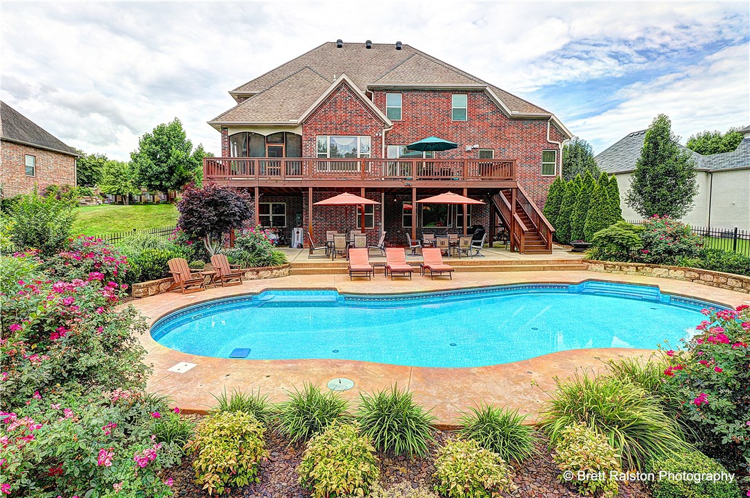 This custom built home sits on a beautiful lot in East Fayetteville's coveted Candlewood subdivision. Candlewood is walking distance to Vandergriff elementary and McNair Middle and less than 1 mile away from upscale grocery, shopping and restaurants! This home sits on almost 1 acre of beautifully landscaped yard with a breathtaking backyard complete with private inground salt water pool. Full walkout basement design has several outdoor living / entertaining areas and multiple decks, one is fully screened in. The house itself boasts multiple living and gaming areas with a full theater room! Custom, chef-worthy kitchen has all the high end finish work you would expect including a double wide built in fridge / freezer. It has an eat-in area with access to the screened in deck and a large formal dining area. 5 bedrooms with the master on the main, 3 up and 1 down. The house has been meticulously maintained and has lots of new paint and carpet. It also features large, flat drive with oversized 3 car garage.