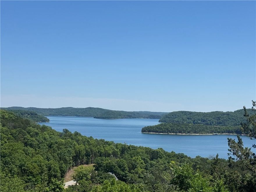 Enjoy breathtaking views of Beaver Lake from this spacious 4-bedroom, 2.5-bath home in Lost Bridge Village. Designed for relaxing and entertaining, the home features a huge upper deck plus a lower-level deck, offering plenty of space to take in the lake scenery year-round. Inside, the living area showcases beautiful wood ceilings and a stunning double-sided stone fireplace shared with the primary bedroom, creating warmth and character throughout. The lower-level game room provides the perfect spot for gatherings, pool games or leisure.  A 2-car garage adds convenience, while most furnishings are negotiable with an acceptable offer, making this an excellent opportunity for a turnkey lake-area getaway or full-time residence. Enjoy all the amenities Lost Bridge Village has to offer, including a community pool, clubhouse, pickleball courts, playground, and close access to the lake. It is currently part of a successful vacation rental program, offering excellent potential for future income opportunities.