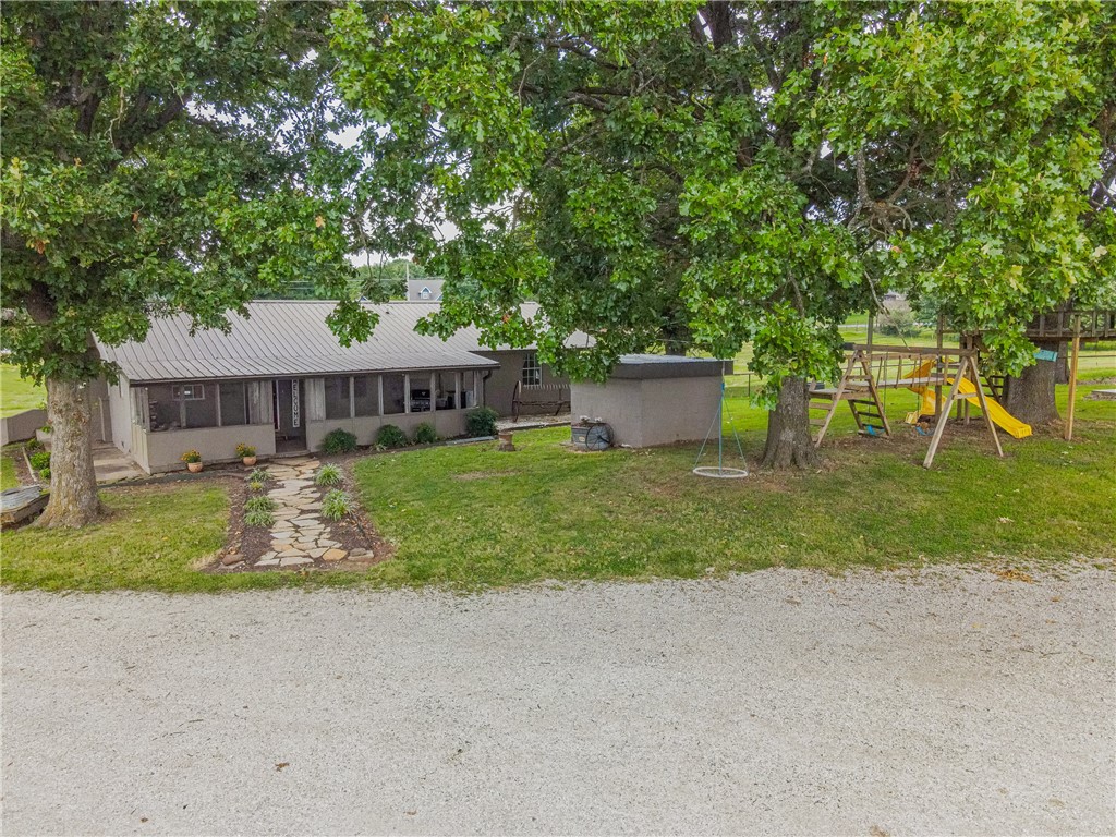 Welcome Home! RARE opportunity to have a farm of your own with the convenience of being in town! 3 bedroom, 2.5 bath home with screened in porch and mature trees. Plenty of outbuildings, beautiful barn and arena for horses, implement building, covered carport and garage space. Over 3,000 ft of pipe fencing surrounds and in-ground pool completes outdoor amenities. Highway frontage makes this a PRIME location for development or single family alike.