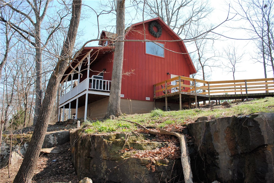 Relax on the deck of this Ozark mountain cabin on almost 7 acres ! Freshly remodeled with a barn feel including sliding barn doors, shutters, & wood reclaimed from old barn. Ozark natural stone fireplace keeps you toasty all winter. All appliances convey w/cabin. Plumbed for central heat and air. Sellers will concede $3000 at closing for purchase and placement of central heat & air unit which only needs to be tied into duct work. This structure is hurricane rated. Septic approved for additional home.