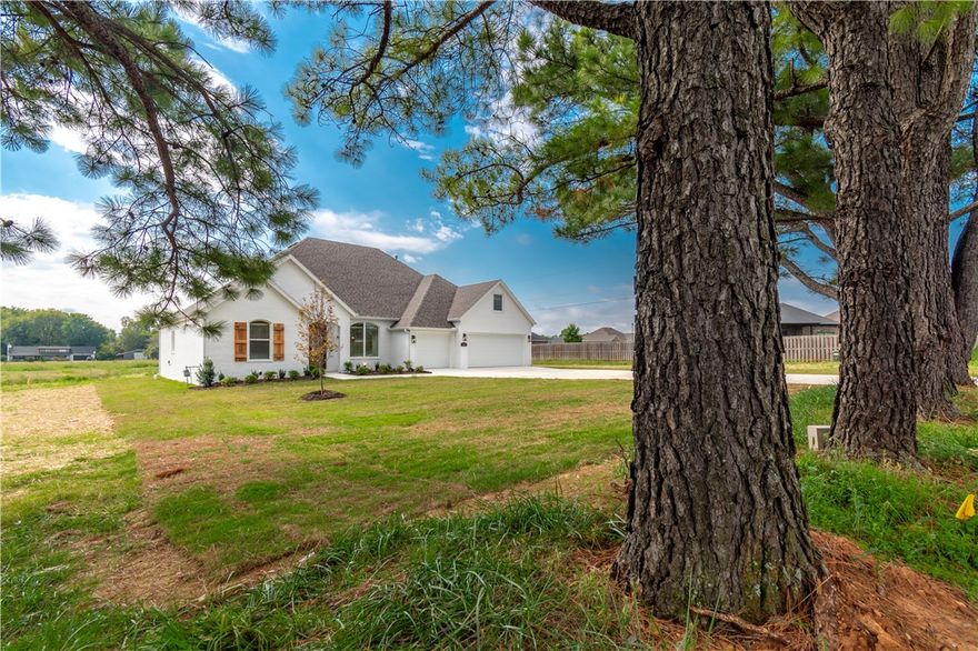 GET A $15,000 CREDIT on this Brand new home sitting on an amazing 1.62 acre lot!   Home features a 3 car garage, beautiful hardwood floors, spacious covered back porch, large kitchen island overlooking the living room, gas range, premium quartz counter tops, custom built cabinets to the ceiling, huge picture windows to soak up the views, mature trees, tiled walk in shower and jacuzzi tub in the primary bathroom, gas fireplace and so much more!  Property has that peaceful country feel, but is only minutes to shopping, dining, parks, trails, schools, i-49, Fayetteville, and all the other great amenities of Northwest Arkansas! 1 year builders warranty! Gutters and Blinds included.