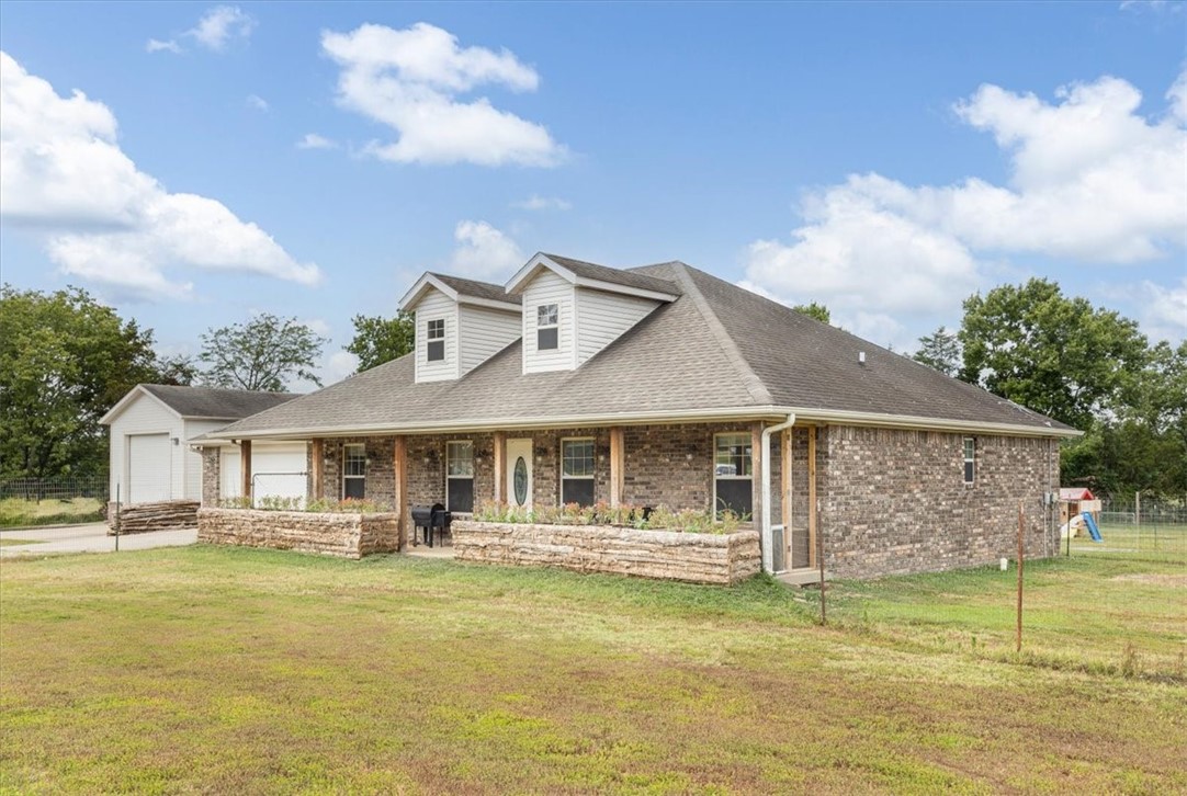 Discover the serene beauty of this 3.3-acre brick home nestled in a picturesque setting, perfect for those seeking tranquility and space. This property offers a blend of comfort, functionality, and room to roam. Step inside this inviting home boasting 3 bedrooms, 2 bathrooms, and an office, providing ample space for both relaxation and productivity. For the hobbyist or car enthusiast, a highlight of this property is the large 2 bay shop building. Wired with 220 amps, it offers endless possibilities for workshops, storage, or pursuing your passions. Outside, enjoy the lush gardens and the pastoral views of fenced and cross fenced grounds, ideal for animals and providing a secure environment. Whether you envision raising livestock, cultivating gardens, or simply enjoying the open space, this property offers the perfect canvas. Located in a rural neighborhood that is less than 20 minutes to Fayetteville and 30 to U of A, this property combines the tranquility of rural living with the convenience of nearby amenities.