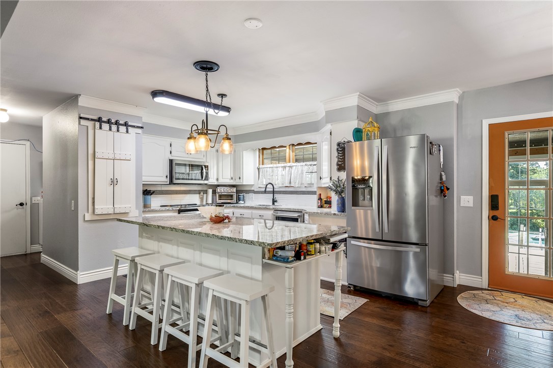 Tucked away on 3 acres, this rare in-town gem offers the best of both worlds: secluded rural living with unbeatable access to schools, parks, and amenities. Fully fenced and full of charm, the property features a massive 2,080 square foot shop with four bay doors, perfect for hobbies, storage, or business needs. The updated kitchen flows into a cozy living room, while the screened porch and hot tub offer year-round relaxation. The spacious primary suite is conveniently located on the main level, with two additional bedrooms and a full bath upstairs. Bonus features include a chicken coop, mature trees, and room to roam. Whether youāre looking for privacy, productivity, or a little backyard homesteading, this one checks all the boxes. Additional 5.4 acres available for purchase. See also MLS numbers 1314772 and 1319631.