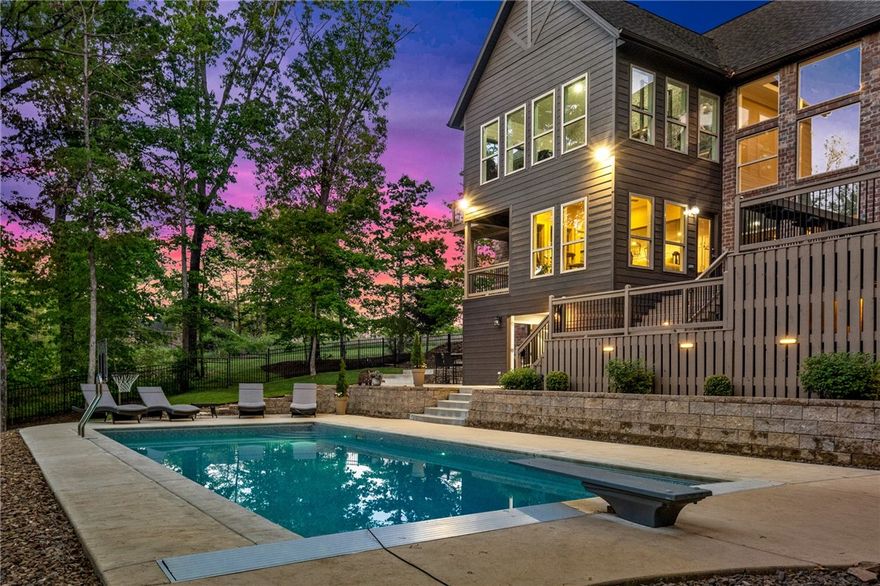 Versailles Estate on 1+ ac w/pool! Secluded setting w/wooded views. 4,744 SF home w/open layout, multiple living spaces, 5 bedrooms & office. Living room w/vaulted ceilings & gas fireplace w/surrounding built ins. Hardwood floors throughout main level. Dining area is open to kitchen & large island w/counter seating. Fantastic kitchen layout provides ample cooking space w/gas range, pantry, wine fridge & double oven. Sunroom has access provides beautiful space to relax. Primary suite & luxurious bathroom w/his & her closets, separate vanities, soaking tub & walk in shower. Upstairs is large media room w/additional space, great option for game/workout area. 4 spacious guest bedrooms & two guest baths on upper level. Enjoy dream outdoor living w/over an acre on private lot, private pool, multi-level deck, large patio. Room on patio level features covered/enclosed space for relaxing poolside. 3 car garage with epoxy flooring. Located in sought after & prime location near schools, bike trails and Downtown Bentonville.