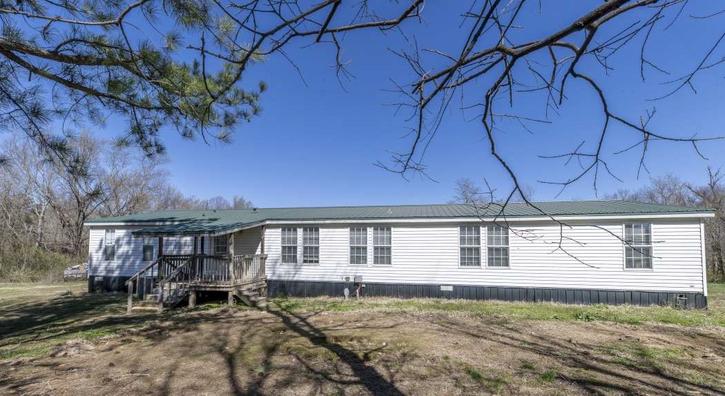 The perfect blend of country living with town conveniences just minutes away! This spacious mobile home sits on 5 private and secluded acres with no restrictions, offering endless possibilities. The land is mostly cleared and flat. It's surrounded by mature trees, and features a seasonal creek—ideal for a hobby farm or your dream home site. Conveniently located just 10 minutes from Beaver Lake this property provides the best of both worlds: tranquility and accessibility. Don’t miss this unique opportunity!