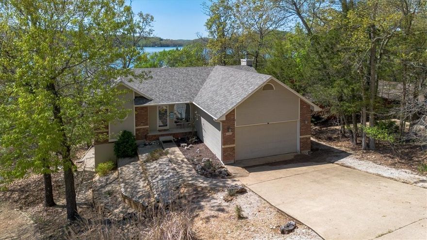 Stunning Lakefront Retreat. Fully Furnished & Nightly Rental Ready! This beautifully maintained 4-bedroom, 3-bathroom home offers everything you need for peaceful lakeside living or a proven income-producing rental. Perfectly positioned with expansive lake views and an easy, gentle walk to the water, you’ll fall in love with this home’s serene setting. Step inside to cathedral ceilings, a cozy stone fireplace, and an inviting split floor plan designed for both privacy and gathering. The open kitchen features granite countertops, a wet bar, and a programmable thermostat for modern comfort. Enjoy your morning coffee or sunset dinners from not 1, but 2 spacious decks overlooking the tranquil waters. The lower level offers a generous family room, additional bedrooms, a second wet bar with fridge, and walk-out access to the hot tub. An attached two-car garage provides plenty of storage for lake toys and gear. Community amenities include a sparkling pool, and with the home being sold fully furnished, it’s truly turnkey!