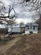 Older mobile that had a metal pitched roof added a few years ago. A 12'x8' addition was added 2 years ago. A nice separate work shed was built recently. Pretty 10 acres with a distant view of the Ozark Mountains. About 3 acres cleared for gardens. Owners are leaving a 1948 Ford tractor(still works), bush hog, dirt scoop, John Deere riding mower and a few more tools. Close to several great trails (including the Compton Trail) that lead down into the Buffalo National River. This would make a fantastic retreat for weekend hikers or retirement home for those that want to make a small investment but enough land to putter around on. Good access with all utilities and close to Harrison for shopping.