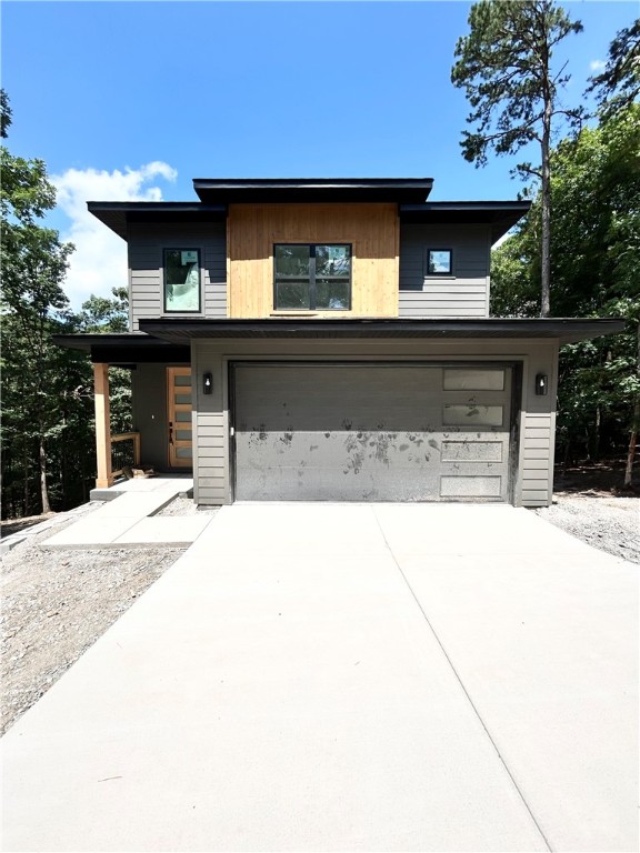 Introducing a stunning modern new construction home on a spacious .32-acre wooded lot, perfectly located near the Back 40 Trail Crossing, Lake Ann boat launch, and Lake Rayburn! As you enter through the impressive two-story entrance, you’ll be greeted by an elegant living space with tons of natural light and a gas fireplace. The kitchen showcases high-end finishes, custom cabinets, and sleek 3 cm quartz countertops, complete with a gas range. The primary bath boasts a luxurious walk-in tile shower for a spa-like experience. No carpet! Step outside to the expansive deck, where you can soak in breathtaking views and enjoy outdoor living at its finest. This home offers a perfect blend of modern design and serene nature, making it an ideal retreat for those seeking luxury and convenience. Bentonville schools!