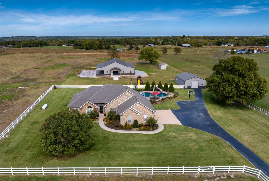 Come home to Nokes Farm Rd and you won't want to leave! This stunning 9+ acre estate features a 4 bedroom custom home that is perfect for entertaining & family gatherings. Dual living spaces, plenty of dining options & cooks dream kitchen. The custom island & abundance of counter-space plus pull out storage make party prep a breeze. The professionally landscaped exterior welcomes you inside a beautiful living space w/ custom millwork & amazing stone stamped faux finish flooring. The double sided fireplace leads into the family room w/ vaulted ceiling, more built-ins & an abundance of windows for enjoying the view. The well appointed primary suite has a jetted tub, separate walk-in shower, large walk-in closet & double sinks. The 4th bedroom also makes a great home office! Outside the heated gunite pool is gorgeous and allows you to swim more than half the year! The sunsets from the pool deck are incredible. A 30x40 shop, a 40x60 barn, 16x12 shed, blacktop driveway & vinyl fence make this a great setup. Agent owned.