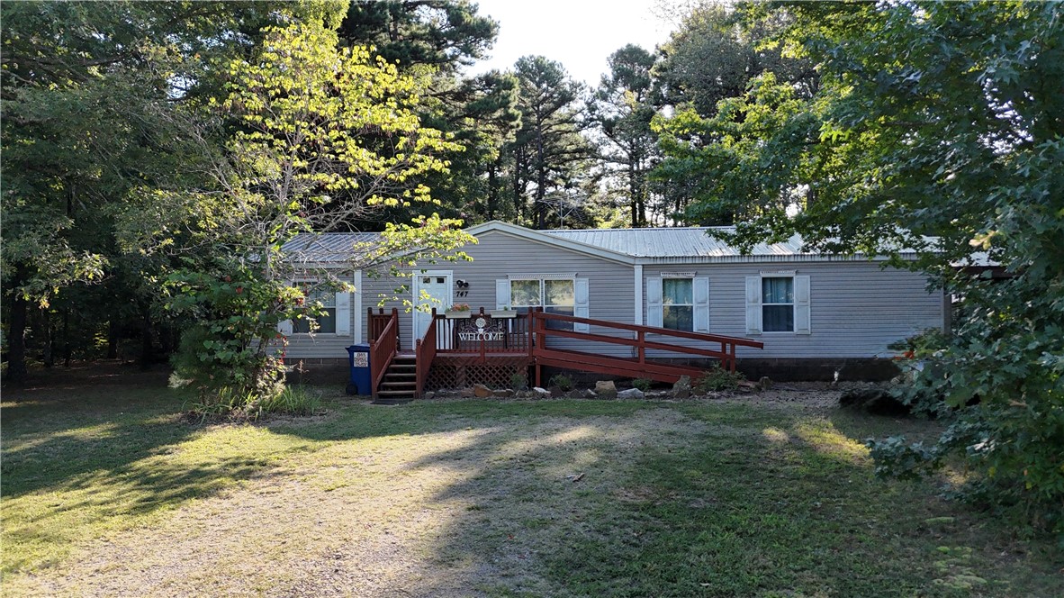 Charming 3BR/2BA manufactured home situated on 0.96 acres, offering the perfect mix of comfort and outdoor living. Enjoy peaceful evenings from the screened-in covered porch or take in breathtaking sunsets from the front porch. Property features a versatile outbuilding and greenhouse, ideal for storage, gardening, or hobbies. With open space and serene views, this home provides both functionality and a welcoming retreat.