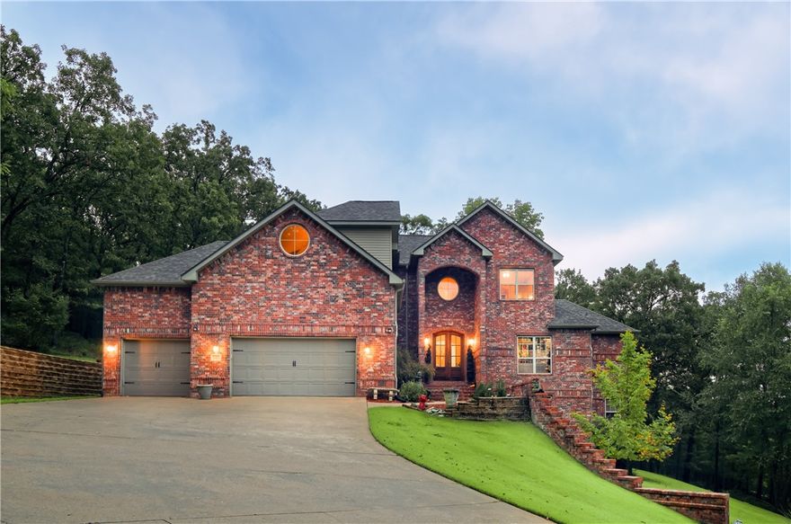 Enjoy your own beautiful East Fayetteville estate surrounded by wooded privacy just minutes from school and shopping. This well-constructed home offers a wide open floor plan with a spacious kitchen and 5 bedrooms, each with a walk-in closet and full baths. The main level has high ceilings, office space, a minibar, and a walkout master bedroom with a dreamy 12' x 18' closet! Upstairs features 3 bedrooms, a large theater/bonus room, and a large landing space overlooking the downstairs formal living room. Downstairs has a large game room with a private walk-out deck and a 5th bed and bath, perfect for an in-laws suite. Entertain or relax out on the large covered back deck with a sunken hot tub while taking in expansive Ozark views. Plenty of storage throughout, along with attic and basement access and a 3-car garage. Beautifully landscaped with plenty of parking. Everything you would expect in a luxury home, without seeing rooftops in every direction.