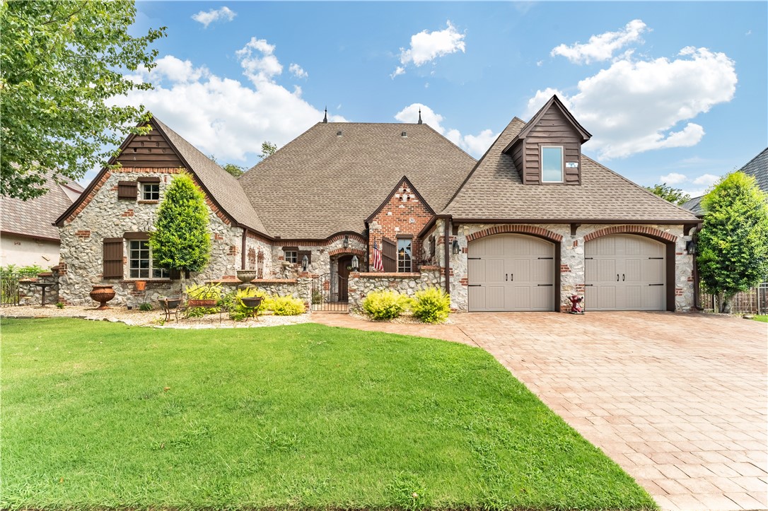 This west Bentonville beauty tucked into Chardonnay subdivision has all the charm of a French country chateau. A wrought-iron gated courtyard and garden lead to the front entry. Inside, rustic design choices bring that fairy tale feeling to life. Arched entries give an open feel to all common areas. Stained concrete floors throughout are heated. The vaulted ceiling is accented with statement lighting and dark wood beams. Large windows overlook the outdoor living area framed by a pergola draped with greenery. The kitchen has custom cabinetry, granite counters, corner sink, breakfast area, and island with range. Primary bedroom has hardwood floors, vaulted ceilings, and a spa-quality bathroom with a soaking tub, dual vanities, walk-in tile shower, private toilet room, and a big walk-in closet with built-ins. Three secondary bedrooms and 2 spare baths are all a good size. Laundry room has a sink, work space, & storage. Backyard is fenced with more wrought-iron. Bentonville West and great schools nearby!