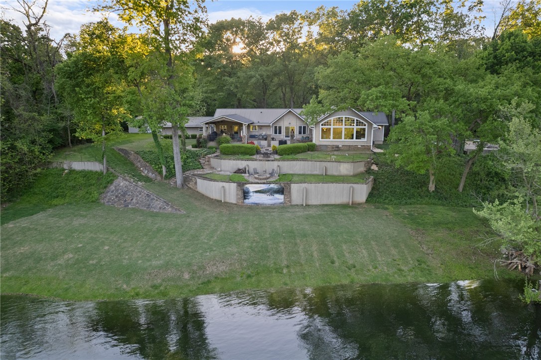 Exceptional river home situated on the White River in the White Hole area, rested on 1.55 ac m/l with 200 feet of river frontage. This impressive property features a spacious 5-bedroom, 4-bath split bedroom design. The custom kitchen is a chefās dream, boasting granite countertops, a large island, newer appliances, and a butlerās pantry. Enjoy the breathtaking great room equipped with a fireplace, cathedral ceilings, and tongue-and-groove accents, all overlooking the river. Additionally, there is a separate living room with fireplace perfect for entertaining guests. Outdoor entertaining is elevated with a large covered grilling area featuring a built-in island with burners, a three-tier stone patio with a built-in fire pit, and artwork by Duane Hada. The entrance showcases a composite front deck with gorgeous landscaping throughout the property plus the property includes multiple heated & cooled garages. Bull Shoals Lake is only five minutes away! This river home truly has it all!