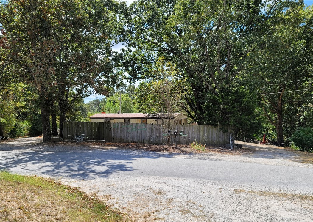 Acreage in Elm Springs has tremendous potential for this diamond in the rough. Property is zoned R-A. It is located in a vast growing area, secluded yet close to shopping, I-49, Hwy 612. Use West entrance to access larger portion of acreage. 3 Water taps on site. One w/meter, 3 separate gas lines at street, need meters. 2 septics on site not warranted. Property is sold as is. Mobile homes are of NO Value. Both parcels to be sold together.