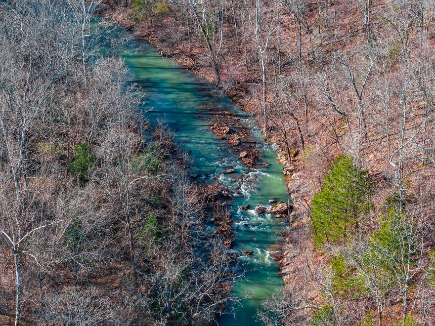 334 untouched acres are a rare find in NW AR and especially when they cradle 1/2 mile of Lee Creek all located only 10 min. from the Ozark Nat Forest, 15 min. from Devil's Den State Park, & 16 min. from the U of A in Fayetteville. As serene as any national park, its beautiful 1920’ elevated mt top entrance along 500 plus ft. of Hwy 170 frontage leads to trails that take you through mt. top views & homesite friendly meadows & beyond through mature trees and dramatic rock outcroppings into the valley. The ½ mi of beautiful Lee Creek works to create its own recreational opportunities in sync with nature. Meander across the creek to discover 2 large meadows where fragments of past inhabitation remain. As recreation areas become more congested, this is an opportunity to invest in your own retreat including 4 plus ponds & a 2nd tributary creek. With electricity & public water plus Ozarks Go Internet, you are invested in the best of access & communication, all within 40 min. of Walmart Headquarters & Crystal Bridges.