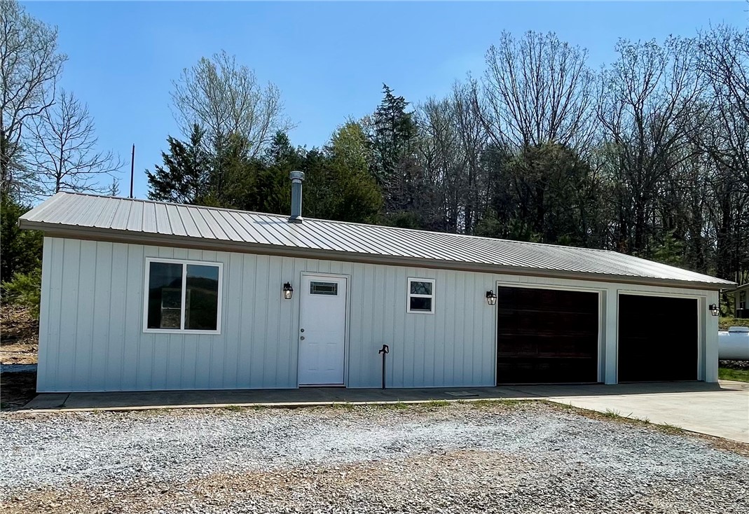 Situated in the Ozarks,this property showcases stunning views,a private & secluded setting, paved roads on 10.73 acres m/l. Improvements with added concrete sidewalks,driveway,a finished basement, new siding & roof on garage & studio apartment with full bath,plumbed & ready for kitchenette, heated & cooled joined by a 2 car garage with lots of room for storage. 2484 sq ft home 3bed/2bath,2 emerg heat options,wood burning stove & propane wall unit.Updated kitchen.New tile/carpet.Wonderful deck to enjoy your own private landscape. Great for outdoor entertaining all year! A roomy finished basement with its own private entrance 1bed/1bath.This property offers great potential with the extra room for guest or extended family! Land has older chicken coop, pole shed for storage,room for animals,some fencing in place but needs work, wet weather creek, 32x50 pole shed offers storage for outdoor equipment & parking! Easy commute to all of NW AR. Approx 30 min or less to Fayetteville, AR & 15 min to Elkins/Huntsville,AR.