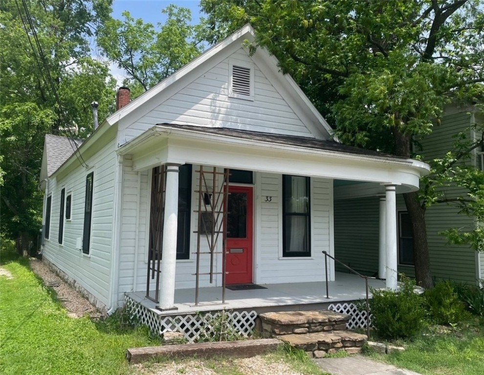 This charming cottage has been remodeled with the perfect blend of old and new. The wraparound front porch is a great spot to visit with neighbors. A vintage front door opens into the living room with heart pine floors and a limestone fireplace. A wide doorway with pocket doors separates the living room from the kitchen and dining areas. The kitchen has new appliances, a pressed tin backsplash and an island. The main bedroom and a guest bedroom are in the back of the house along with one and a half baths. The full bath has a modern clawfoot tub with a shower. You'll appreciate the closets and stacked washer and dryer. A sunroom stretches across the back of the home and a French door opens onto a composite deck. The back yard is fenced and there is an 8' x 14' outbuilding with electric service. All the rooms have 10-foot ceilings and original windows with new black storm windows. New composite wood back deck. Quick walk to your favorite Spring Street shopping and dining. Can not be a nightly rental.