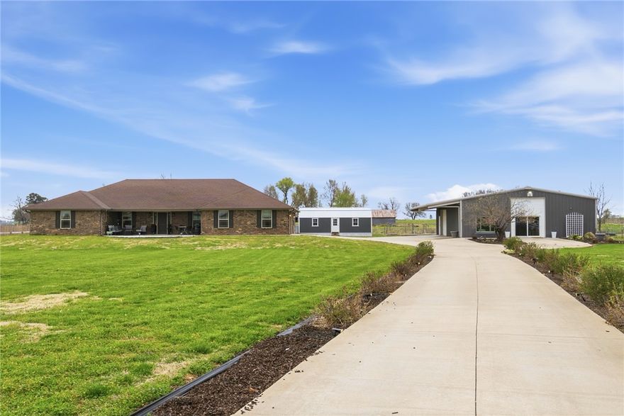 A one-of-a-kind property in the heart of Farmington — two homes, 5 bedrooms, and over 3,399 SF of living space on 2 acres. The brick main home (2,409 SF)   offers a wide-open floor plan with granite kitchen, split bedrooms, home office, mudroom, and multiple flex rooms for offices or playrooms. Covered front   porch perfect for entertaining. Garage with tornado shelter and EV charging station. Everything updated — new flooring, paint, lighting, and AC. Next door, a   40x50 red iron building houses a completely independent 990 SF home with its own HVAC and septic, plus 1,010 SF of workshop with drive-through roll-up   doors. Whether it's a guest house, rental income, or multi-generational living, the possibilities are endless. The grounds include a 480 SF office shed with   100-amp power, greenhouse, 215 ft of raised beds, rose garden, thornless raspberries, and a ready-to-use chicken coop. White vinyl fencing, new concrete   patio, and high-speed fiber internet to both homes.