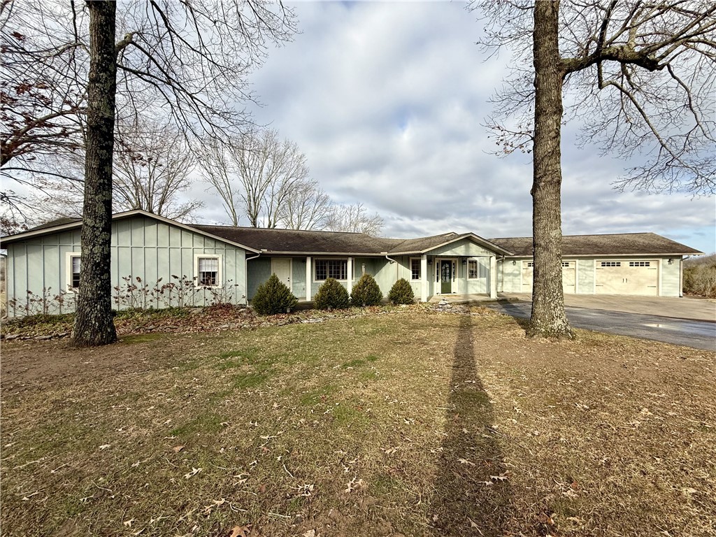 Absolutely beautiful! Enjoy the distant views from every window and the covered deck. The exterior features concrete siding & brick, spacious covered front porch, with oversized two car garage and a detached workshop with garage door and carport storage area. Interior open floor plan with living, kitchen and dining with a propane gas log fireplace and hardwood floors, primary bedroom with an amazing walk-in tile shower, and walk-in closet, 2 bedrooms, 1 full-bath with a mud room and additional storage. Basement features, large family room with propane gas log fireplace, 2 bedroom, full bathroom, storage room and a workshop. All of this is situated on 34.97 acres m/l, just minutes to WalMart, 30 minutes to Branson, MO. A Must SEE!