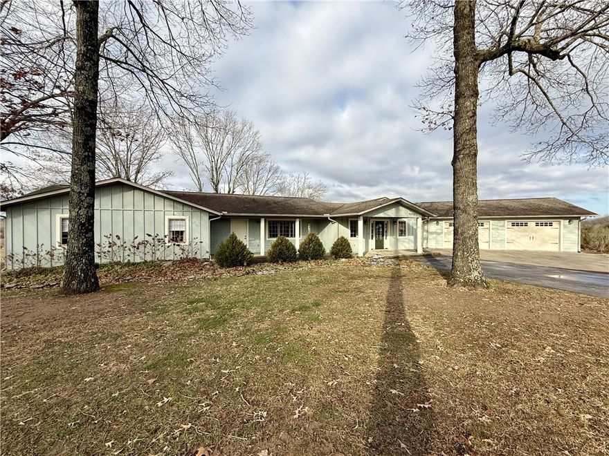 Absolutely beautiful! Enjoy the distant views from every window and the covered deck. The exterior features concrete siding & brick, spacious covered front porch, with oversized two car garage and a detached workshop with garage door and carport storage area. Interior open floor plan with living, kitchen and dining with a propane gas log fireplace and hardwood floors, primary bedroom with an amazing walk-in tile shower, and walk-in closet, 2 bedrooms, 1 full-bath with a mud room and additional storage. Basement features,  large family room with propane gas log fireplace, 2 bedroom, full bathroom, storage room and a workshop. All of this is situated on 34.97 acres m/l, just minutes to WalMart, 30 minutes to Branson, MO. A Must SEE!